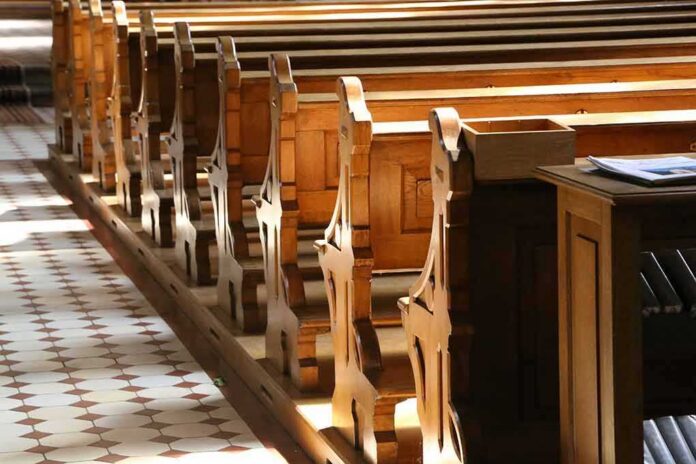 shutterstock_1152589436-1 wooden church pews in sunlight
