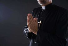 Abortion Link Exposes Catholic Cash Network Clergyman in black robe praying with hands together