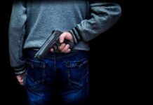 Stadium Night Turns BLOODY : Kids Caught In Crossfire person holding a handgun behind their back