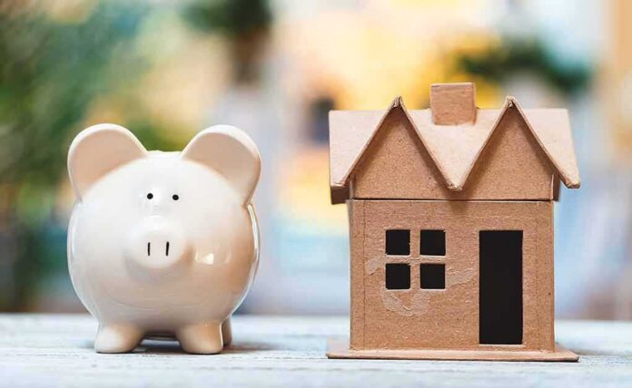 Piggy bank beside cardboard house model on a table