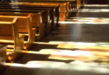 SANCTUARY TSUNAMI Ahead – 100,000 Churches On The Block Wooden church pews with stained glass light on the aisle