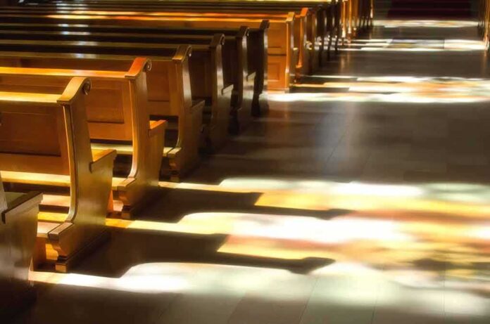 shutterstock_125481890-2 Wooden church pews with stained glass light on the aisle