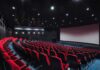 empty movie theater with red seats and large screen