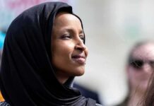 Ilhan Omar in profile wearing a black headscarf outdoors