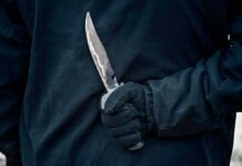Lockdown Panic – Schoolyard Stabbing Chaos Grips California Gloved hand holding a serrated knife against a dark jacket