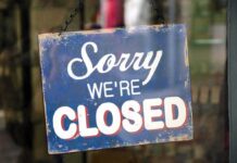 Paris on Edge: Louvre Shuts Down Hanging closed sign on a shop door