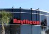 Raytheon Scores Big – What’s Washington Betting? Raytheon logo on a modern glass office building