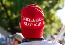 MAGA Trap Springs – Rogers Won’t Bite person wearing a red baseball cap at an outdoor gathering