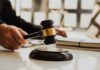Immigration Clash: DOJ Moves to Muzzle Bench Judge's gavel striking sound block on a desk