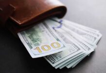 Gallego’s Power Play: Middle Class Fix – or Job Killer? Wallet with US hundred-dollar bills fanned out