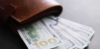 Wallet with US hundred-dollar bills fanned out