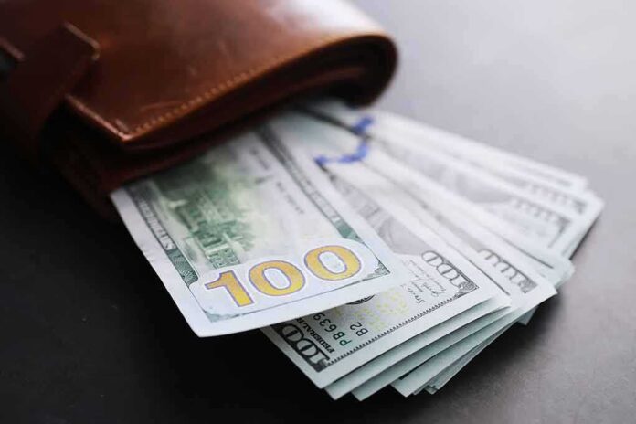 Wallet with US hundred-dollar bills fanned out