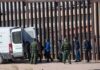 DHS Crackdown: Worst-Of-The-Worst – Or Window Dressing? Border agents escort a group near a tall fence and a patrol van