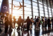 Kremlin Skies Go Dark – Airports Grind To Halt Passengers queue inside an airport terminal at sunset