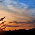 Silhouette of missile launchers at sunset