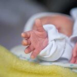 Protective Guardrail Vanishes For Abortion Survivors Newborn hand reaching out on a blanket