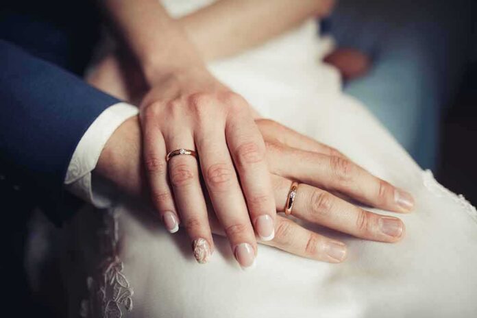 shutterstock_344075921-1 Hands with wedding rings resting together