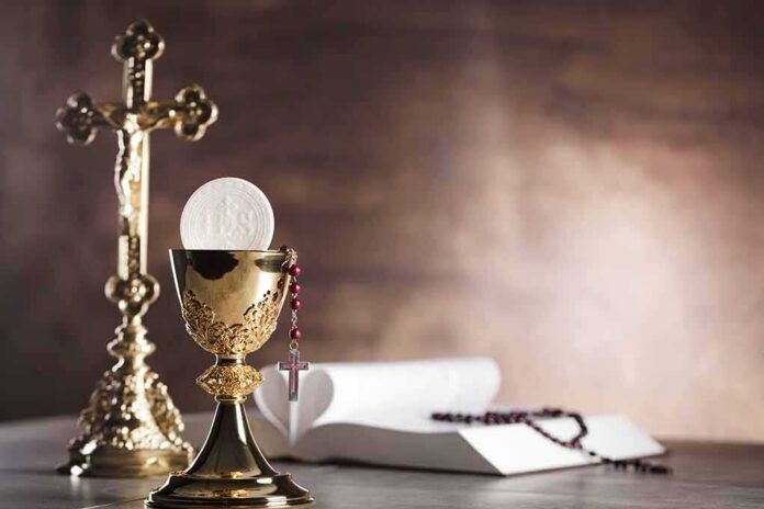 Golden chalice with communion wafer and rosary