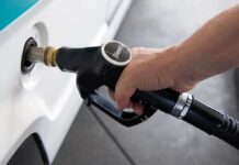 A hand holding a diesel fuel nozzle while refueling a vehicle