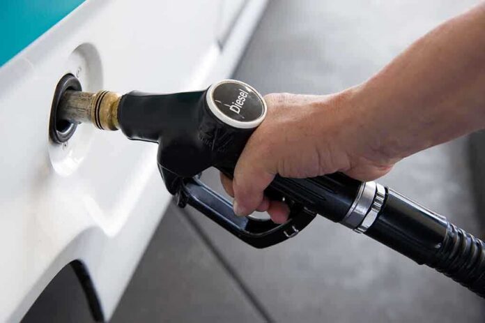 shutterstock_86606614 A hand holding a diesel fuel nozzle while refueling a vehicle